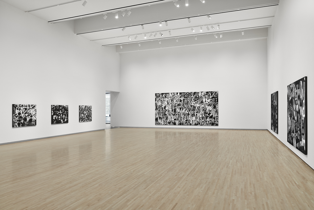 A gallery space with six large black-and-white paintings on the walls