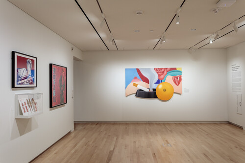 A view of a gallery with colorful artworks hung on the walls.
