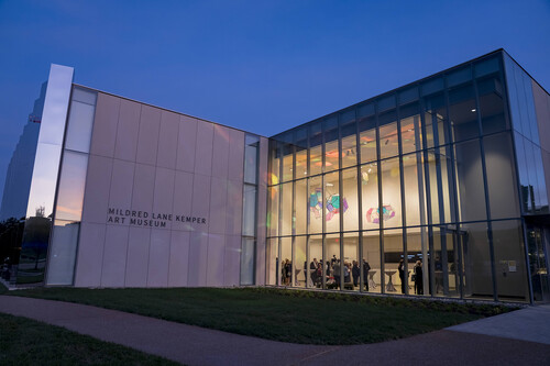 Exterior of the Kemper Art Museum at night with people indoors visible through the windows 